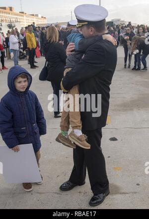 NORFOLK, Va. (Dec. 16, 2018) Cmdr. Chad Kaiser, the Arleigh Burke-class guided-missile destroyer USS Forrest Sherman (DDG 98) executive officer, hugs his son on the pier during the ship’s homecoming. Forrest Sherman returns to Naval Station Norfolk following the Harry S. Truman Carrier Strike Group’s (HSTCSG) deployment in support of maritime security operations and theater security cooperation efforts in the U.S. 2nd, 5th and 6th Fleet areas of responsibility. Stock Photo