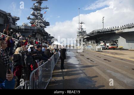 NORFOLK, Va. (Dec. 16, 2018) Sailors' families and friends wait on the pier during the Nimitz-class aircraft carrier USS Harry S. Truman (CVN 75) homecoming. Truman returns to Naval Station Norfolk following the Harry S. Truman Carrier Strike Group’s (HSTCSG) deployment in support of maritime security operations and theater security cooperation efforts in the U.S. 2nd, 5th and 6th Fleet areas of responsibility. Stock Photo