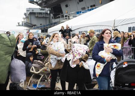 NORFOLK, Va. (Dec. 16, 2018) Families await the arrival of the Nimitz-class aircraft carrier USS Harry S. Truman (CVN 75) during the ship’s homecoming. Truman returns to Naval Station Norfolk following the Harry S. Truman Carrier Strike Group’s (HSTCSG) deployment in support of maritime security operations and theater security cooperation efforts in the U.S. 2nd, 5th and 6th Fleet areas of responsibility. Stock Photo