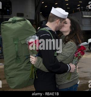 NORFOLK, Va. (Dec. 16, 2018) Logistics Specialist 2nd Class Wyatt Easter kisses his wife on the pier during the Nimitz-class aircraft carrier USS Harry S. Truman (CVN 75) homecoming. Truman returns to Naval Station Norfolk following the Harry S. Truman Carrier Strike Group’s (HSTCSG) deployment in support of maritime security operations and theater security cooperation efforts in the U.S. 2nd, 5th and 6th Fleet areas of responsibility. Stock Photo