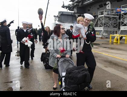 NORFOLK, Va. (Dec. 16, 2018) Sailors walk with their families and friends on the pier during the Nimitz-class aircraft carrier USS Harry S. Truman (CVN 75) homecoming. Truman returns to Naval Station Norfolk following the Harry S. Truman Carrier Strike Group’s (HSTCSG) deployment in support of maritime security operations and theater security cooperation efforts in the U.S. 2nd, 5th and 6th Fleet areas of responsibility. Stock Photo