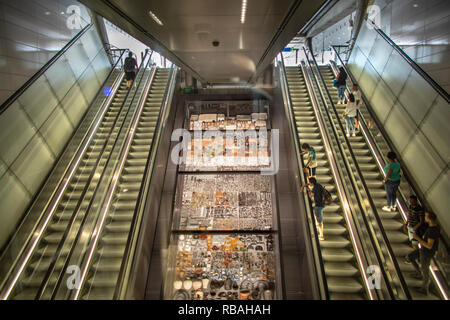 The Netherlands, Amsterdam, Subway, metro. North/South line. Noord/Zuid lijn. Escalator in Rokin station. In the middle presentation of objects which  Stock Photo