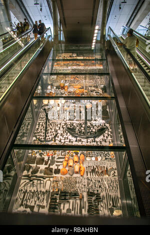 The Netherlands, Amsterdam, Subway, metro. North/South line. Noord/Zuid lijn. Escalator in Rokin station. In the middle presentation of objects which  Stock Photo