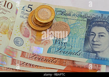 Bank Of England plastic £5 £10 Five pound and ten pound bank notes, with coins Stock Photo