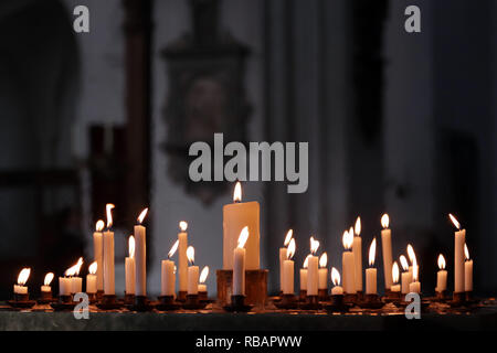 Candles lit by worshippers in a Christian church. Stock Photo