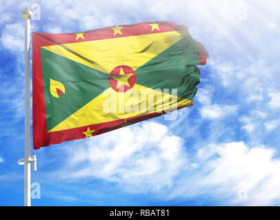 Grenada National Flag Waving on pole against deep blue sky background ...