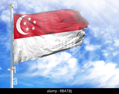 National flag of Singapore on a flagpole in front of blue sky. Stock Photo