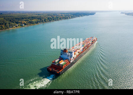 Aerial view of a container ship going upstream in the St. Lawrence River near the port of Montreal in Canada
