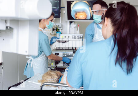 Team of doctors in hospital at endoscopy examining pictures Stock Photo