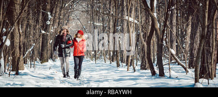 Couple having a winter walk on a chilly cold day in the woods Stock Photo