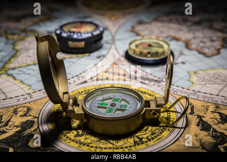 compasses on old world map as concept Stock Photo