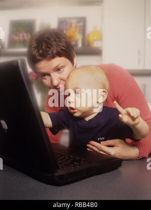 Mother and toddler son on a laptop computer enjoying screen time together Stock Photo