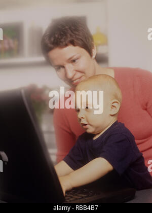 Mother and toddler son on a laptop computer enjoying screen time together Stock Photo