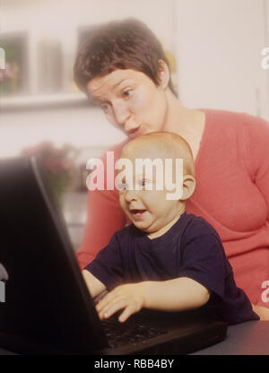 Mother and toddler son on a laptop computer enjoying screen time together Stock Photo