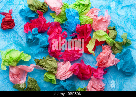 Crumpled colorful tissue paper on a blue tissue paper background Stock Photo