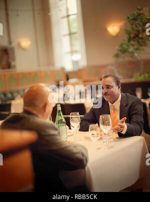 Two business men having a serious discussion at the table of a restaurant. Stock Photo