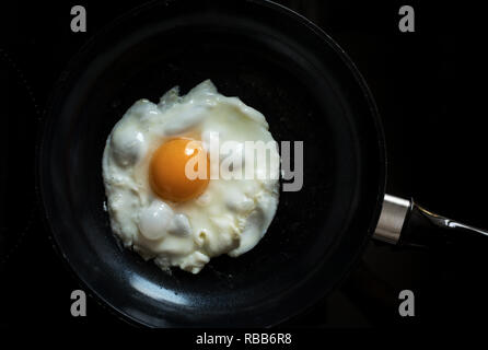 Egg fried on black pan in morning.Food and cooking concepts ideas Stock Photo
