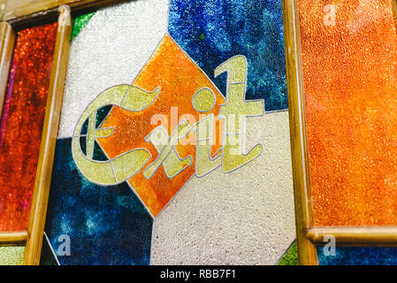 Exit word in an antique engraving on the colorful glass of a door. Stock Photo
