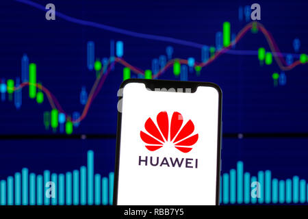 Huawei logo is seen on an android mobile phone over stock chart Stock Photo
