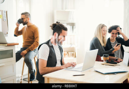 Group of young businesspeople with laptop working in a modern office. Stock Photo