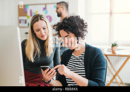Group of young businesspeople with laptop working in a modern office. Stock Photo