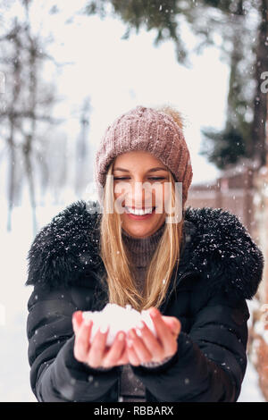 Beautiful woman holding snow in her hands. Stock Photo