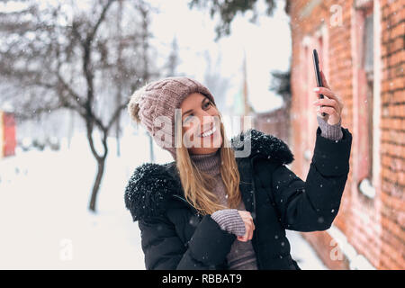 Woman having video call outdoors at Winter. Stock Photo