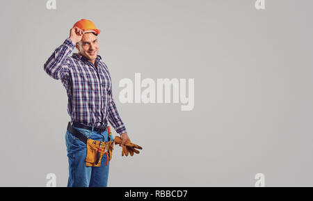 Smiling adult constructor in hardhat and greeting Stock Photo