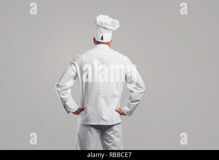 Chef cook in white uniform standing back view . Stock Photo