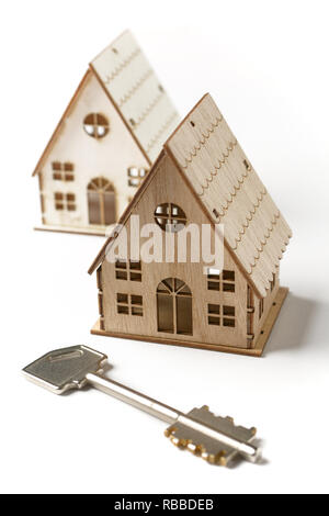 small model of house on a white background with keys to the side - closeup Stock Photo