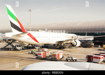 Dubai, UAE - October 31, 2018: Airplane of Emirates company, parked at Dubai's international airport dock, loading goods and preparing before the flig Stock Photo