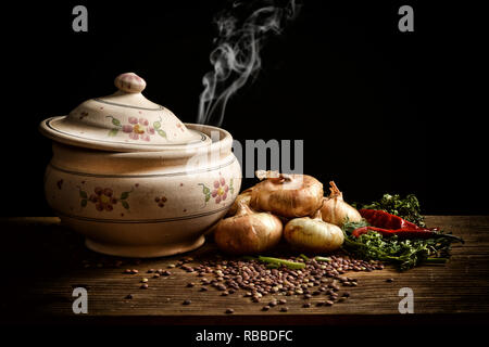 lentil soup in the earthenware bowl with ingredients around on black background - closeup Stock Photo