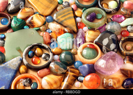 Close up of semi precious tumbled gemstones, cabachons, rings and pendants Stock Photo