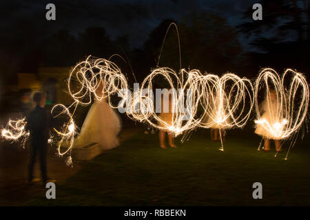 sparklers being whizzed around on a wedding day in the semi dark, by wedding guests, sparkler patterns in the dark, long exposure Stock Photo