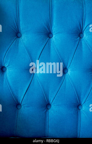 Texture,classic blue sofa upholstery with light fabric buttons. Stock Photo
