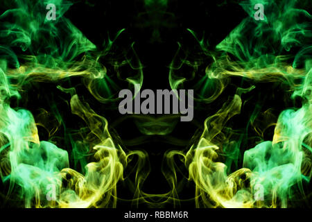 Thick colorful green  and yellow smoke  in the form of a butterfly on a black isolated background. Background from the smoke of vape. Mocap for cool t Stock Photo