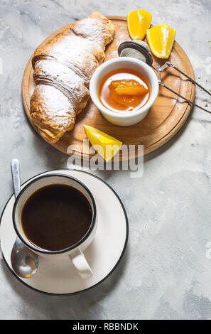 Breakfast served with coffee, croissants and fruits on concrete background Stock Photo