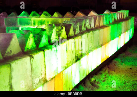 A wall of ice with multi-colored lighting. Ice blocks. Stock Photo