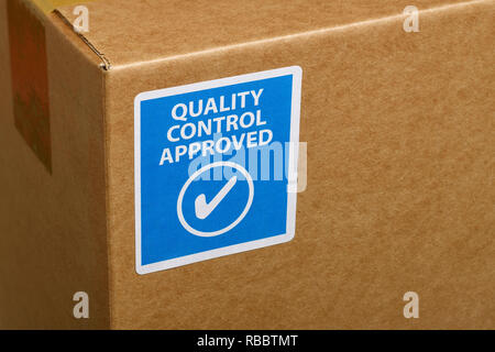 A Quality Control Approved sticker attached to the corner of a cardboard box Stock Photo