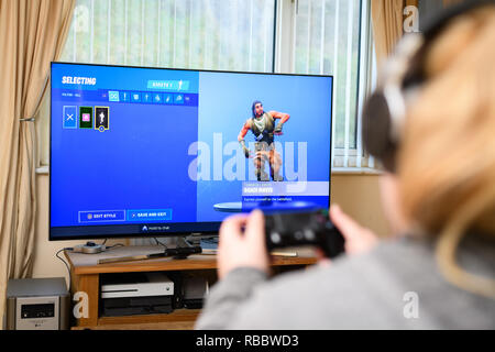 Cardiff, Wales - January 09, 2019: Teenager Girl playing Fortnite video game, Fortnite is a web based multi player survival game developed by Epic Gam Stock Photo