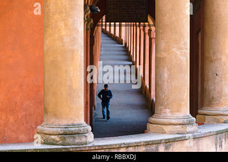 Man is coming back from the famous landmark San Luca using its famous portico Stock Photo