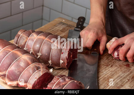 Butcher preparing venison meat at the Gog Farm Shop, Stapleford, Cambridge, Cambridgeshire Stock Photo