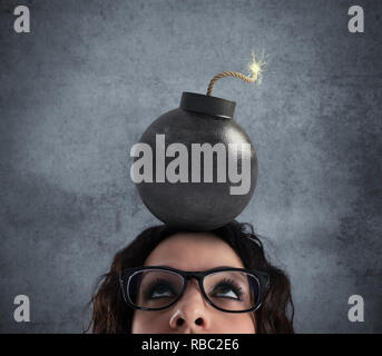 Businesswoman stunned by strong headache with a bomb over the head Stock Photo