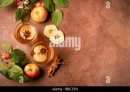 Cocktail of ripe fresh apples with cinnamon in glass glasses on a dark background. Apple cider, a drink with cinnamon and thyme. Autumn concept. View  Stock Photo