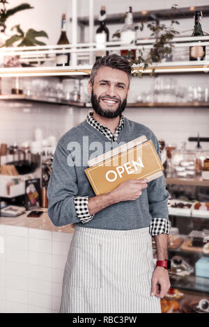 Cheerful positive man greeting you in his bakery Stock Photo