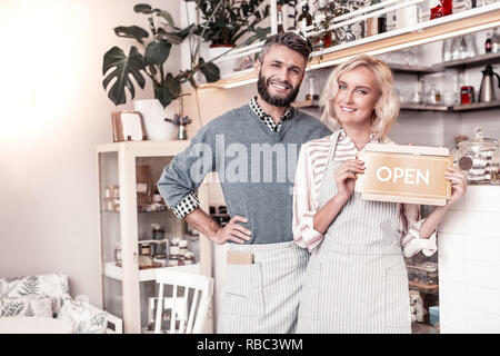 Delighted happy young couple opening their own cafe Stock Photo