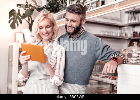 Positive joyful young woman holding a tablet Stock Photo