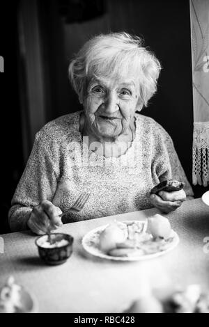 Elderly russian woman portrait dines in his home. Black and white. Stock Photo