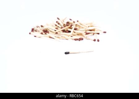Picture of many match sticks and one burnt matchstick. Isolated on the white background. Stock Photo