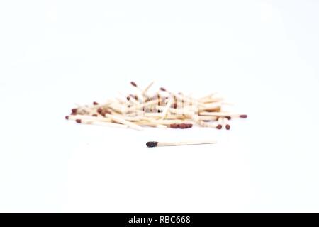 Picture of many match sticks and one burnt matchstick. Isolated on the white background. Stock Photo